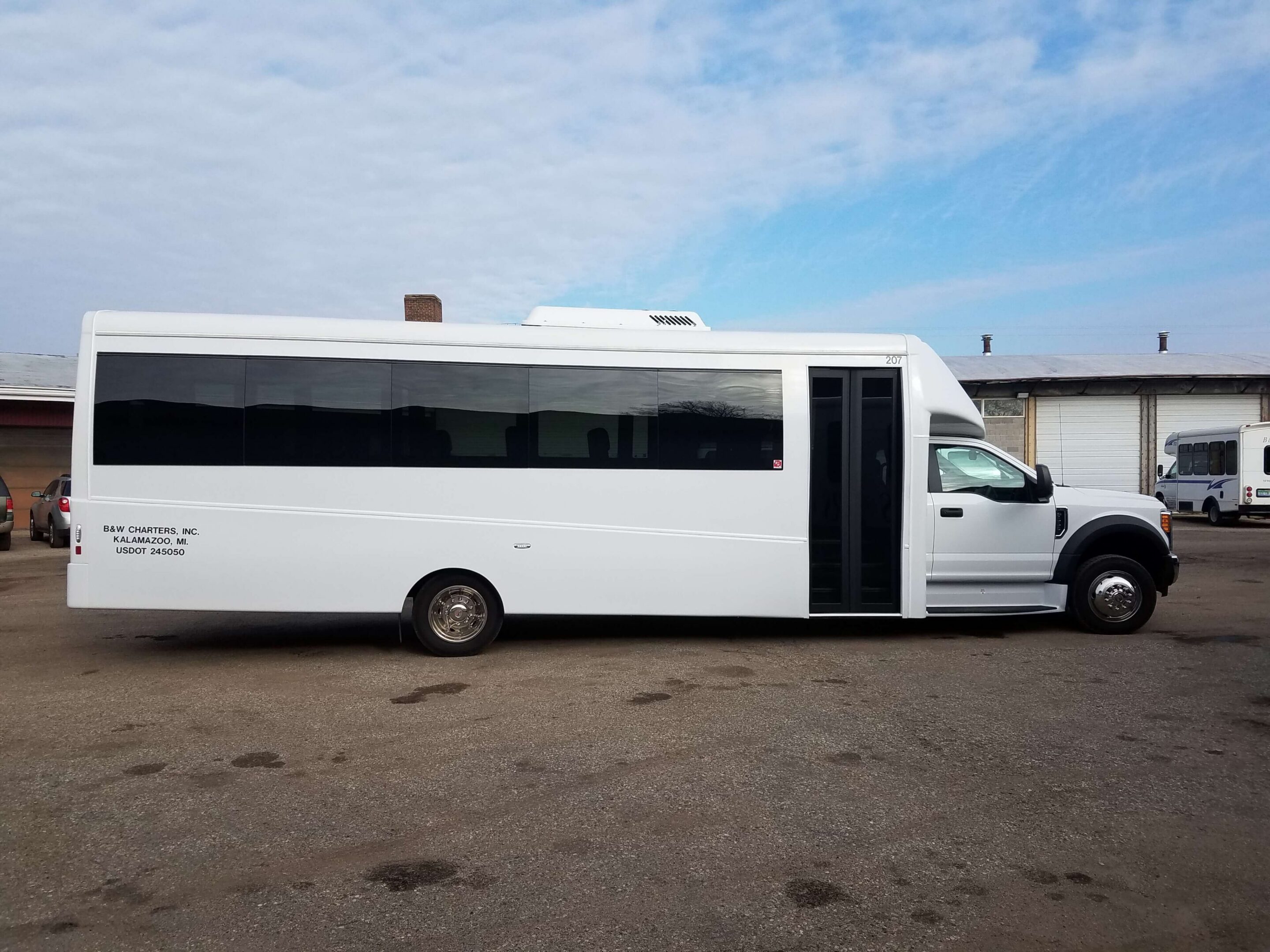 White shuttle bus parked near industrial building