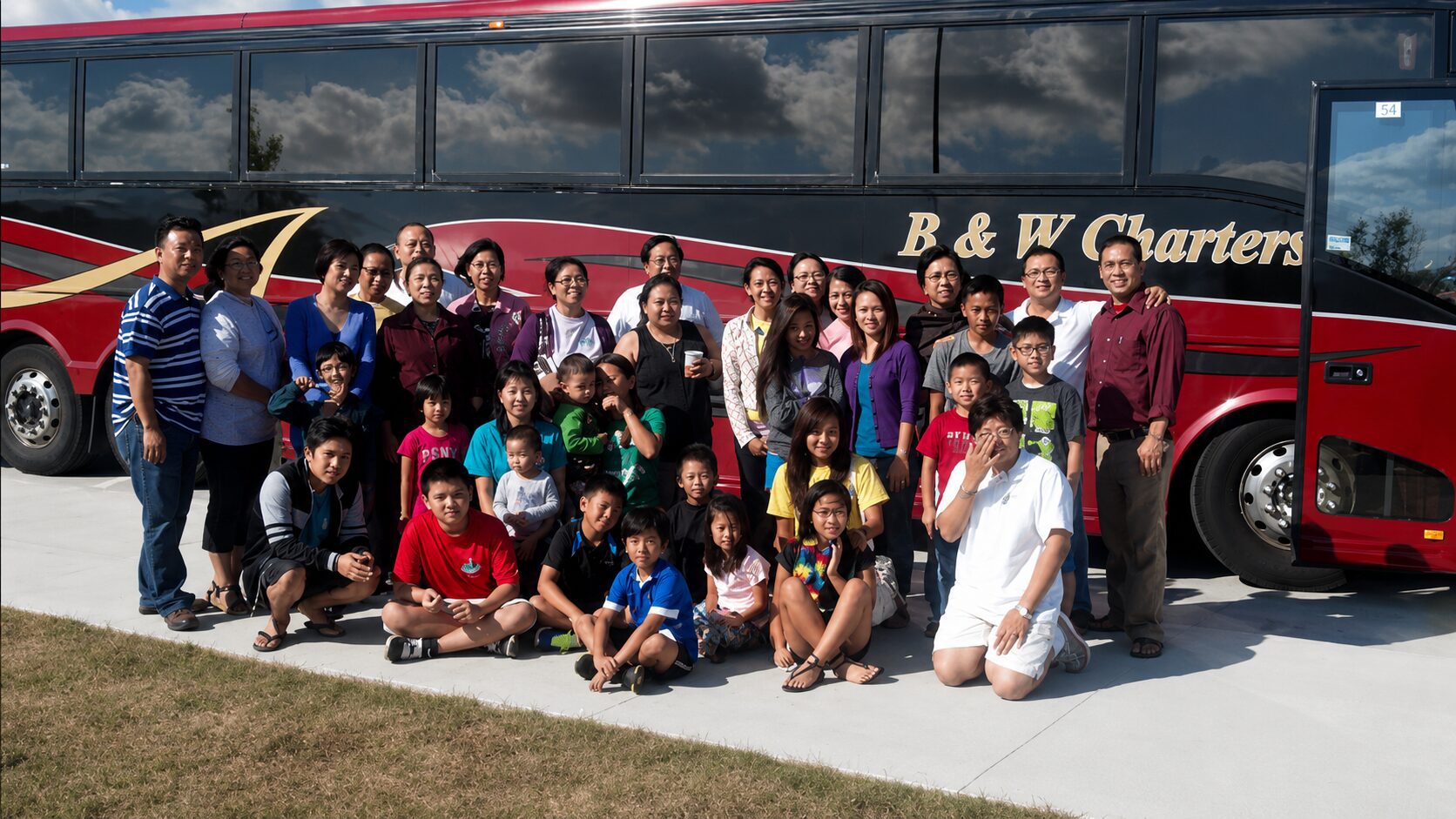 Group posing in front of charter bus