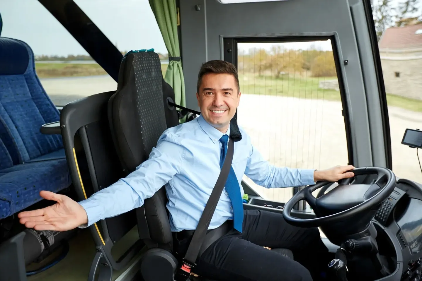 Smiling bus driver gesturing while driving coach