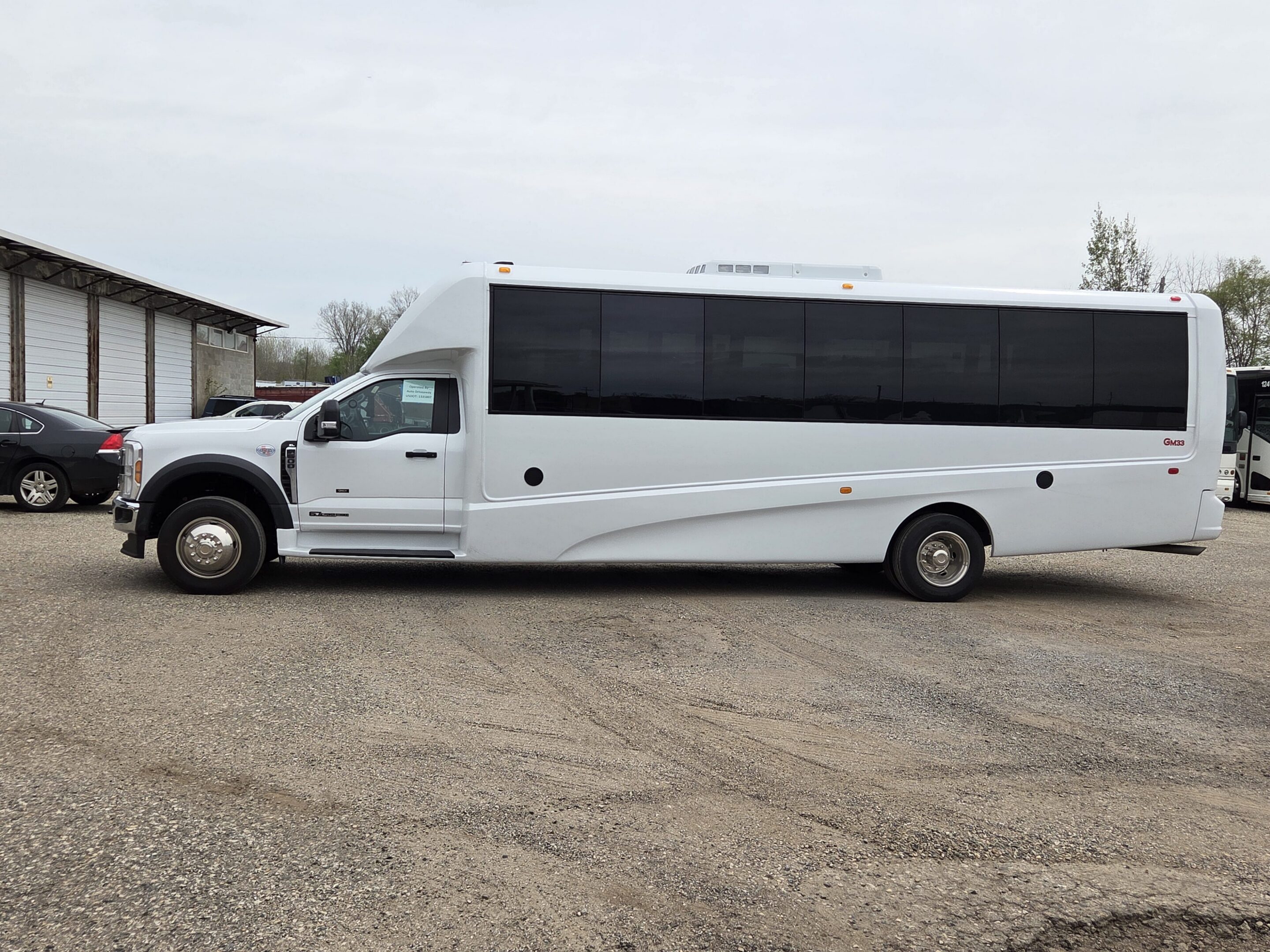 White shuttle bus parked on gravel