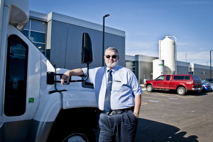 Truck driver leaning on white delivery truck