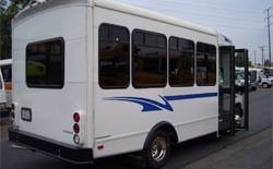 White shuttle bus with blue side stripe