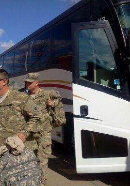 Soldiers boarding white coach bus