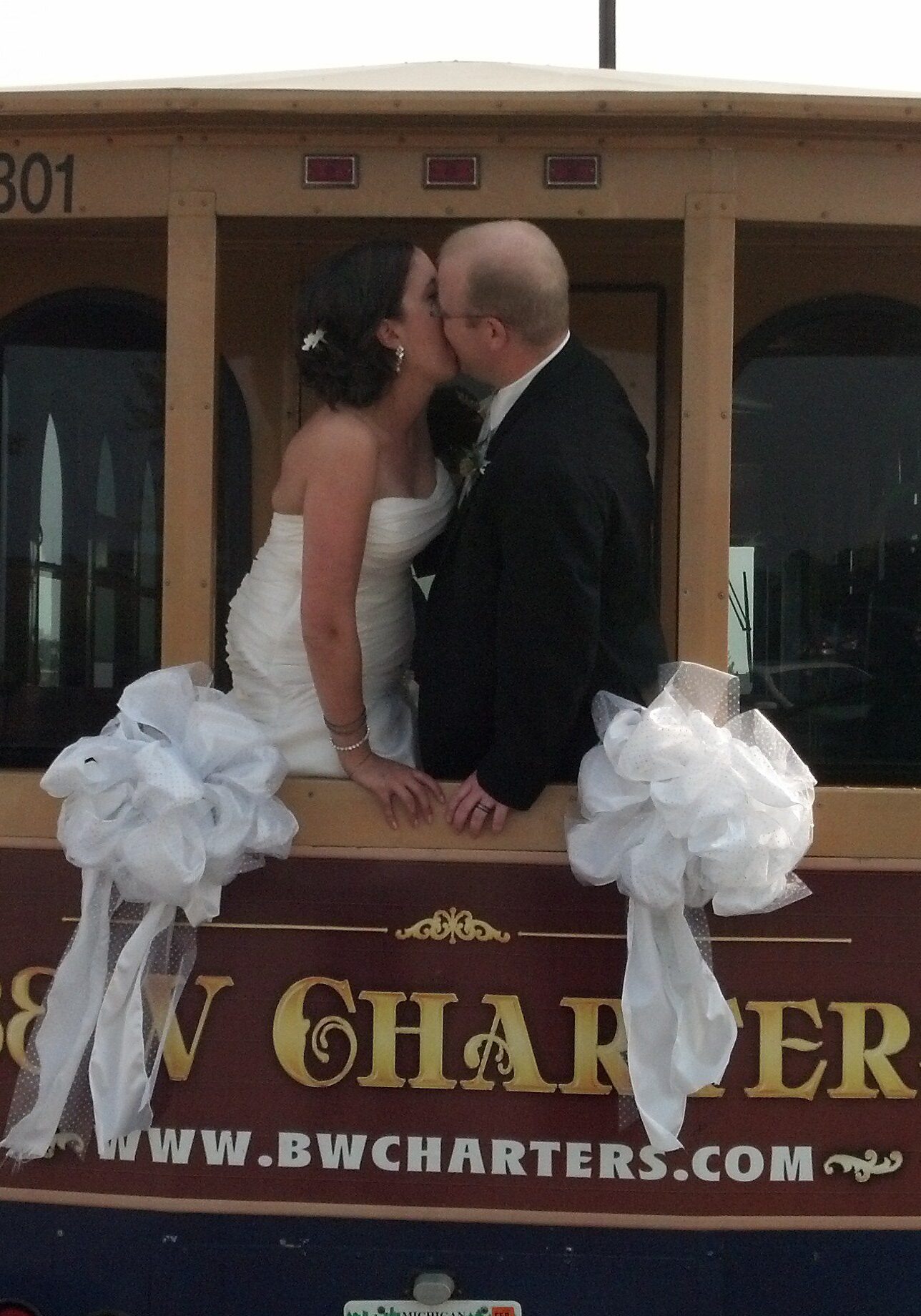 Bride and groom kissing on wooden trolley